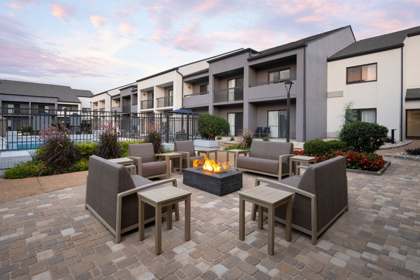 Outdoor fire pit patio with lounge seating at sunset